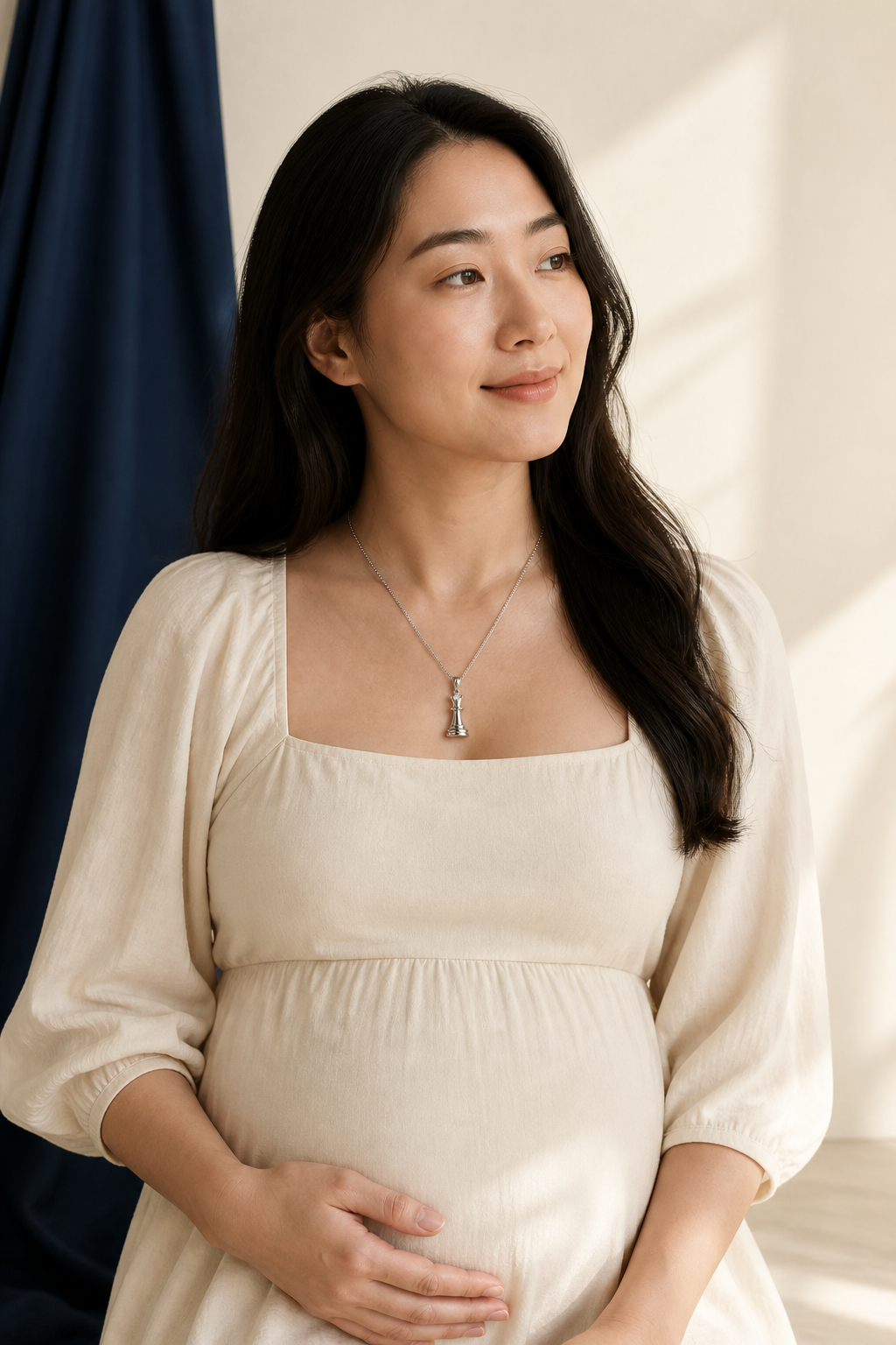 An expectant adult mother wearing the silver-tone Queen Necklace; the necklace is for adult wear only.